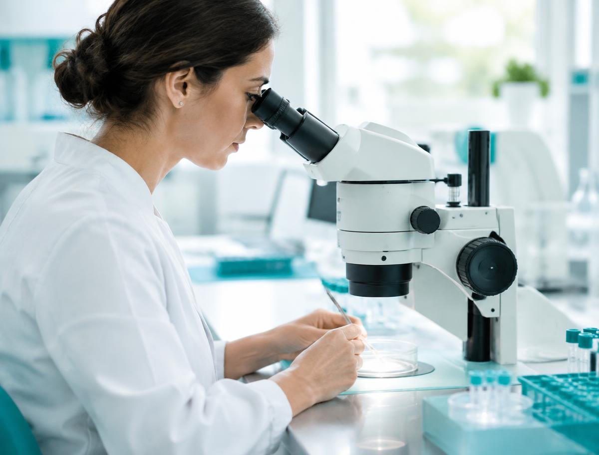 Embryologist examining a culture dish under a microscope in a fertility laboratory